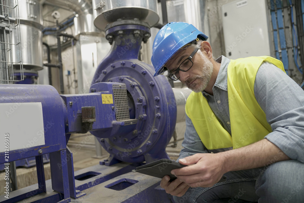 Industrial technician connected with tablet in recyling plant Industrial technician connected with tablet in recyling plant