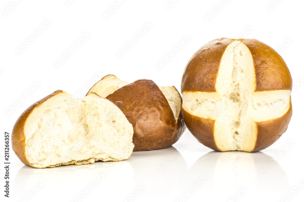 Two Bavarian bread buns and one broken half isolated on white background fresh baked loaves.