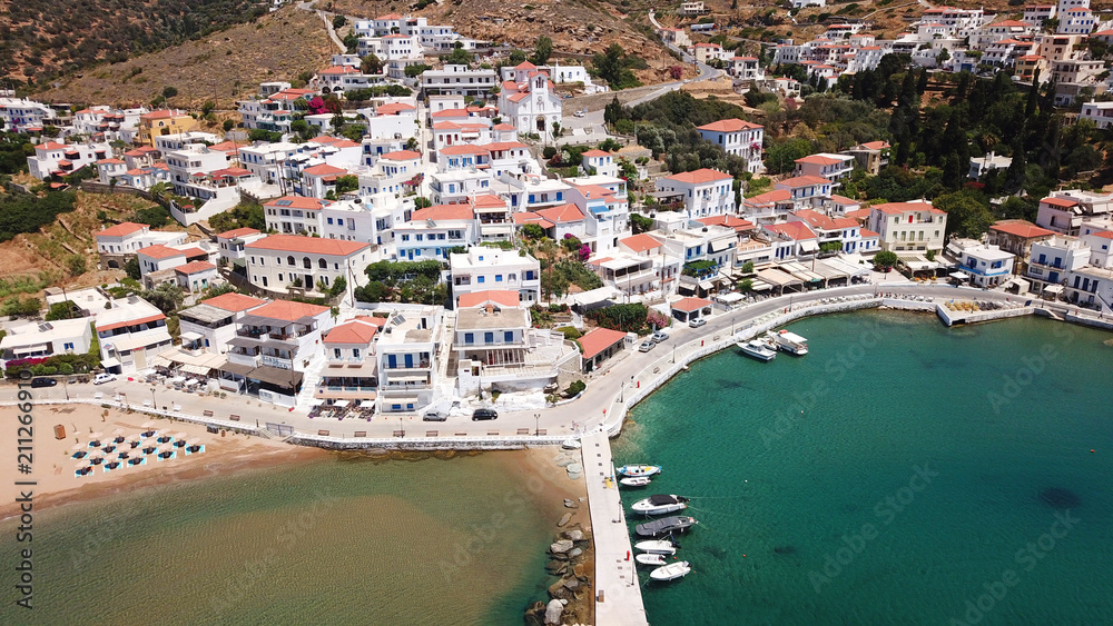 Aerial drone bird's eye view of picturesque village of Batsi with traditional taverns and clear water beach, Andros island, Cyclades, Greece