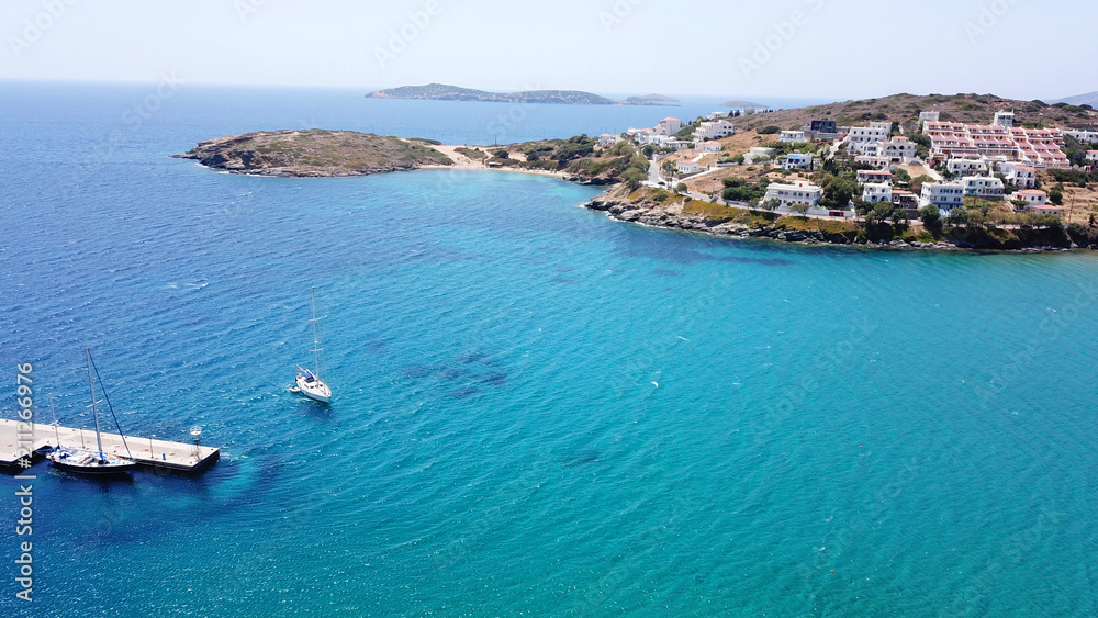 Aerial drone bird's eye view of picturesque village of Batsi with traditional taverns and clear water beach, Andros island, Cyclades, Greece