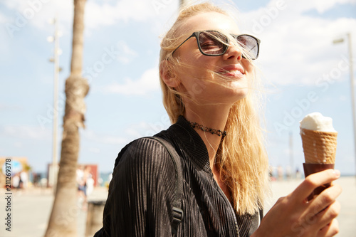 A girl enjoying ice-cream on the beach of Barcelona