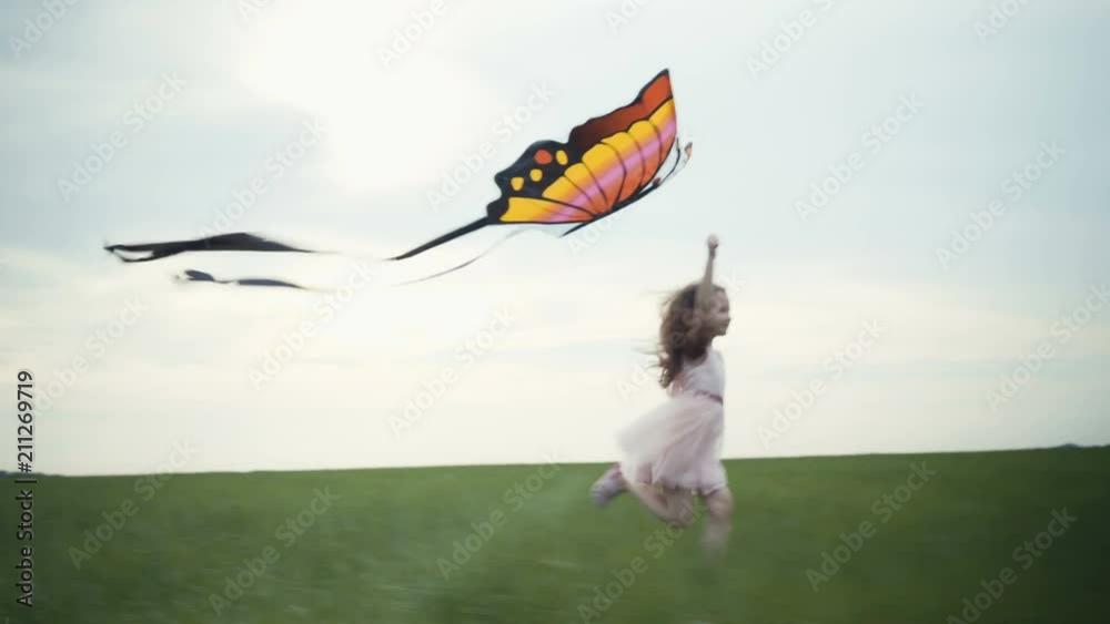 girl running around with a kite on the field. Freedom concept.