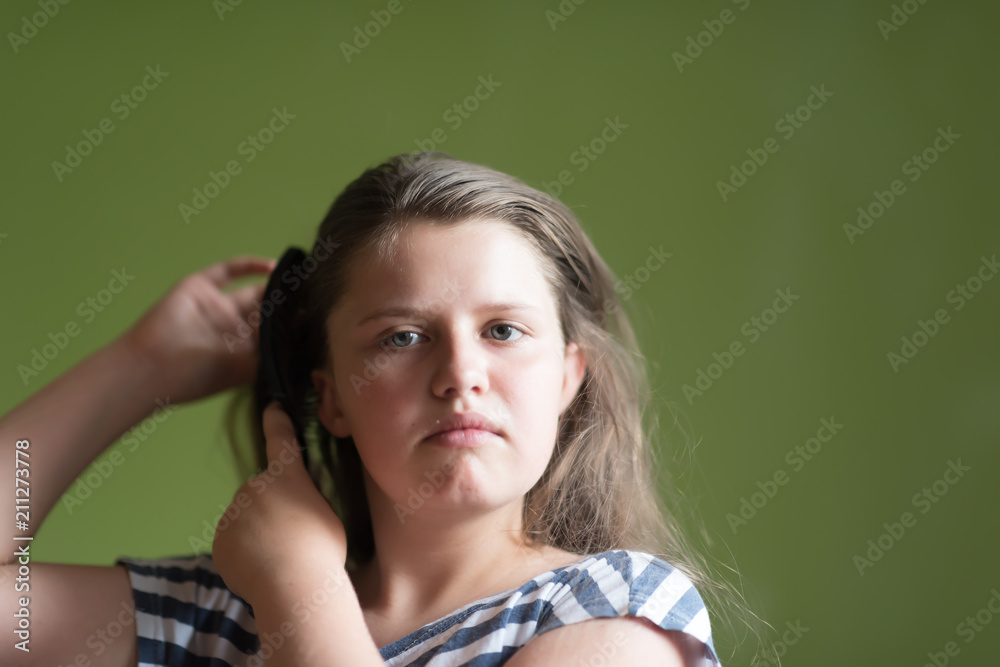 Young girl in pyjama brushing her long dark-blond hair after getting up in the morning Young girl in pyjama brushing her long dark-blond hair after getting up in the morning