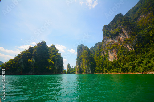  Mountain scenery with tropical rainforest behind and blue water lake at Ratchaphruek dam at Khao Sok National Park, Surat Thani