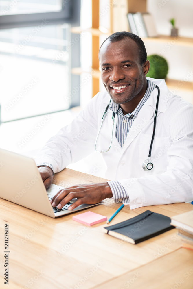 Pleased brunette sitting at his workplace Pleased brunette sitting at his workplace