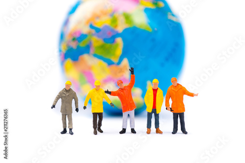 Miniature people, group of workers standing on mini planet background using as business, logistics and industry concept