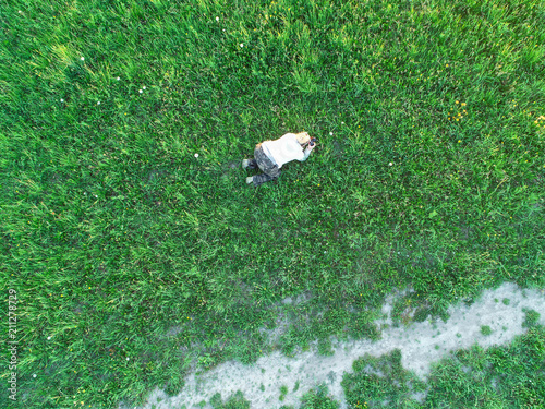photographer on a green field photographs insects and flowers photo from a height