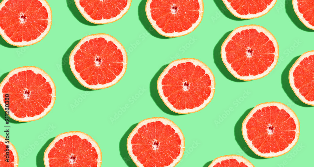 Halved fresh grapefruits on bright color background