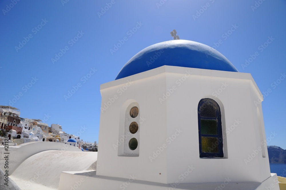 Famous stunning view of white architectures and church above the volcanic caldera in the village of Oia in Santorini island, Greece
