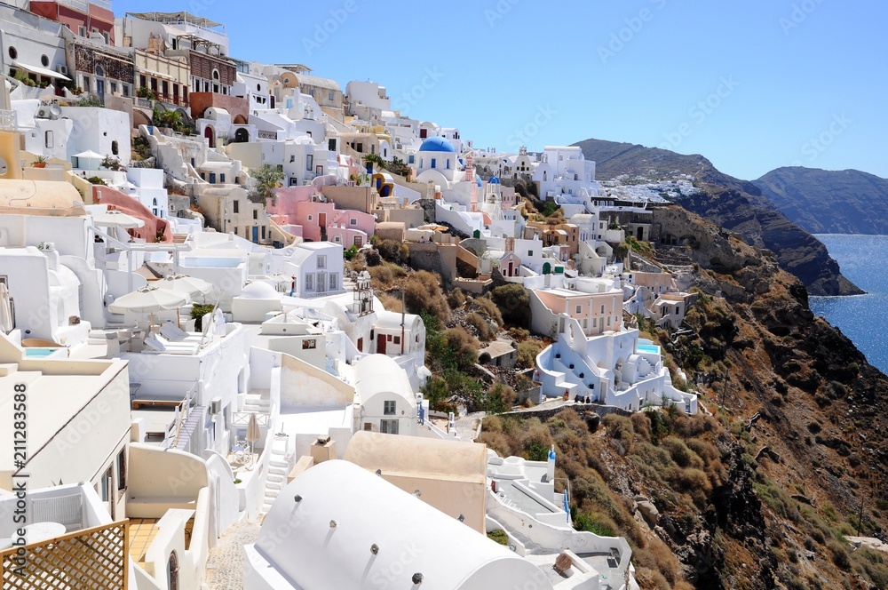Famous stunning view of white architectures and colors above the volcanic caldera in the village of Oia in Santorini island, Greece