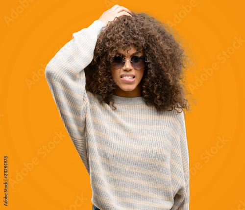 African american woman wearing a stripes sweater stressed with hand on head, shocked with shame and surprise face, angry and frustrated. Fear and upset for mistake. © Krakenimages.com