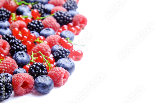 Bunch of mixed berries in harvest pile on white background. Colorful composition with fresh organic strawberry  blueberry  blackberry   redcurrant. Clean eating concept. Close up  copy space  top view