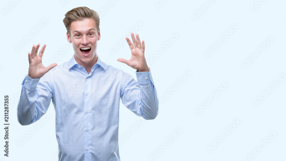 Young handsome blond man very happy and excited, winner expression celebrating victory screaming with big smile and raised hands Young handsome blond man very happy and excited, winner expression celebrating victory screaming with big smile and raised hands