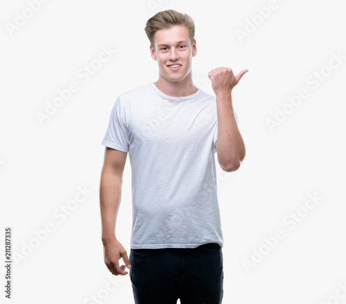 Young handsome blond man pointing with hand and finger up with happy face smiling