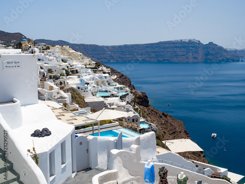 Beautiful Oia town, Santorini island, Greece: Panoramic view. Traditional and famous white houses and churches with blue domes over the Caldera, Aegean sea.