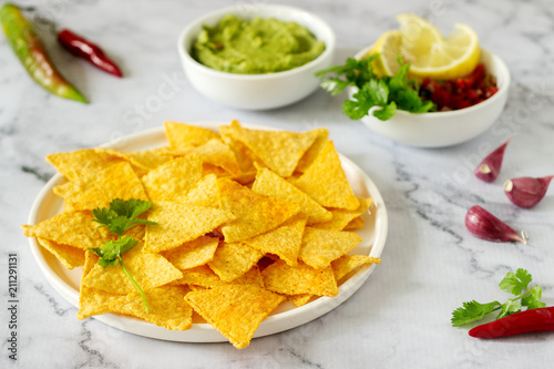 A traditional Mexican snack nachos served with sauces of guacamole, pico de gallo or salsa. photo