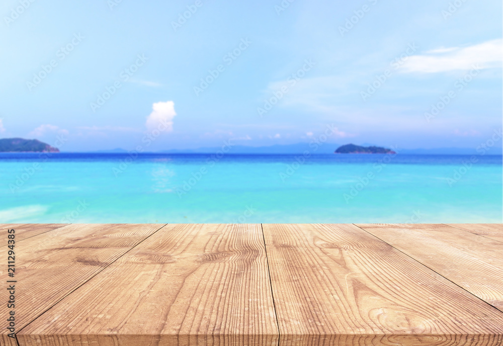 Fototapeta premium Wood table with blue sea and sand beach background