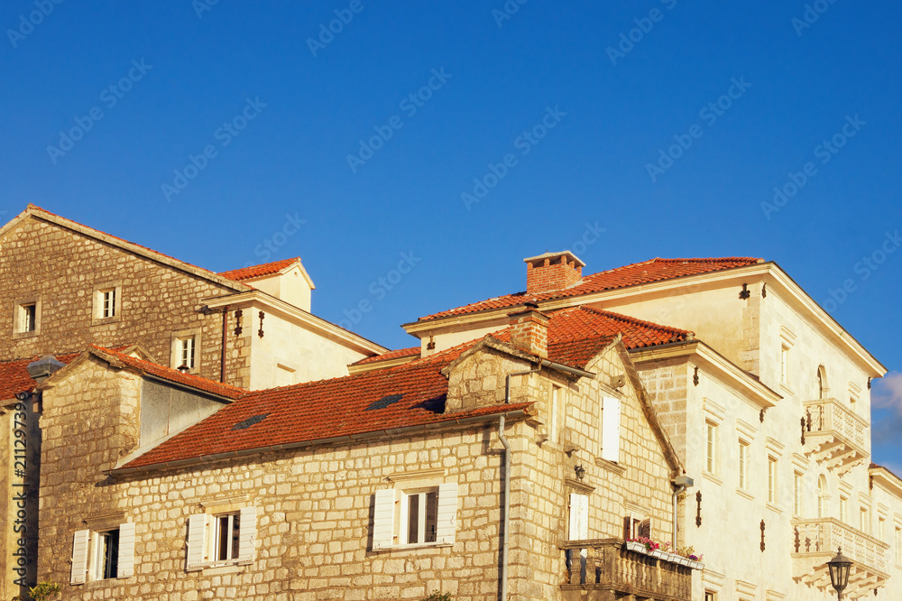 Old houses with red roofs under blue sky. Ancient town of Perast, Montenegro Old houses with red roofs under blue sky. Ancient town of Perast, Montenegro