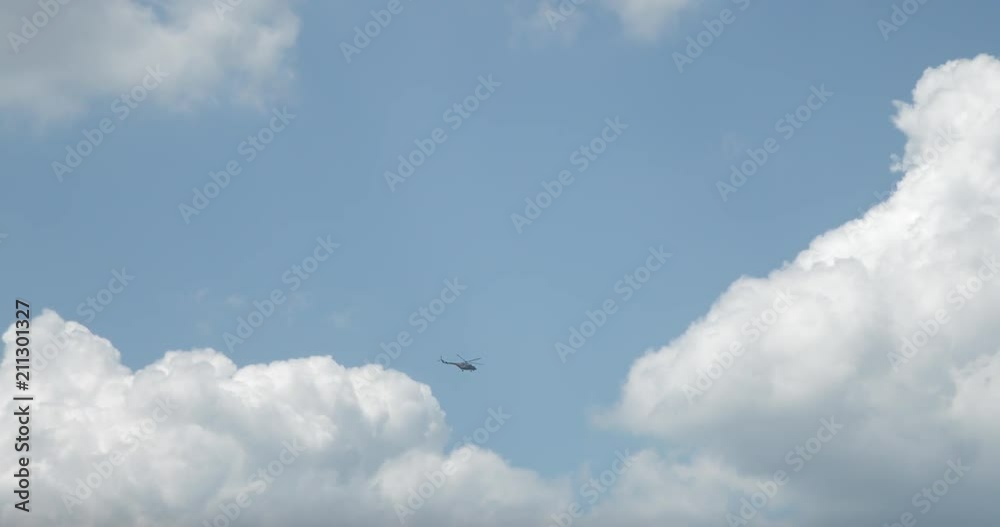 helicopter against a blue sky and white clouds