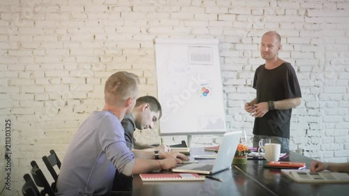 Creative coworkers team is having presentation and activily gesticulate while discussing charts. Business partnership