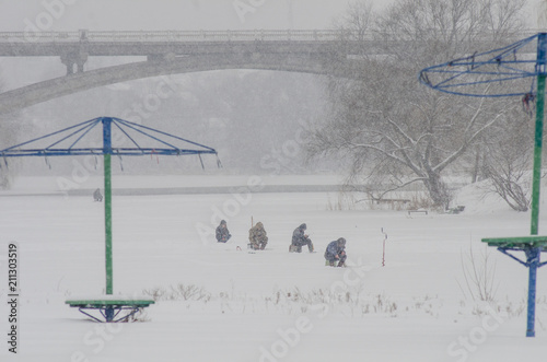 Fishermen on the river catching fish in the snow