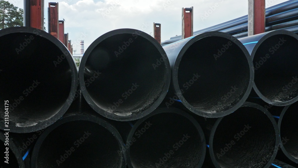 Warehouse of finished plastic pipes industrial outdoors storage site. Manufacture of plastic water pipes factory. Process of making plastic tubes on the machine tool with the use of water and air Warehouse of finished plastic pipes industrial outdoors storage site. Manufacture of plastic water pipes factory. Process of making plastic tubes on the machine tool with the use of water and air