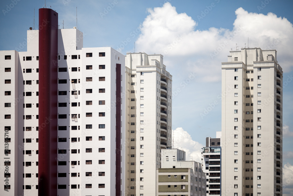 Graphic visual of skyscrapers with blue sky and fluffy clouds Graphic visual of skyscrapers with blue sky and fluffy clouds