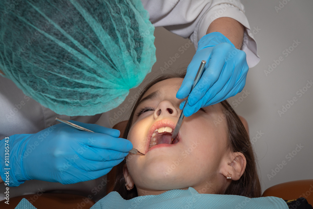 children's dentist conducts a professional examination of the girl