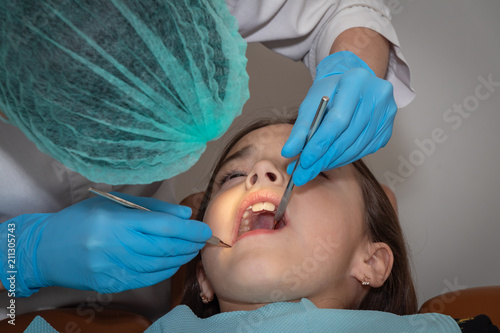 children's dentist conducts a professional examination of the girl