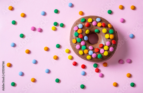 Donut chocolate glaze and sprinkles, top view and isolated, on pink  background.