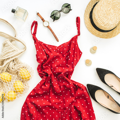 Summer female fashion composition. Red dress, straw, string bag, sunglasses and lemons on white background. Flat lay, top view clothes and accessories background.