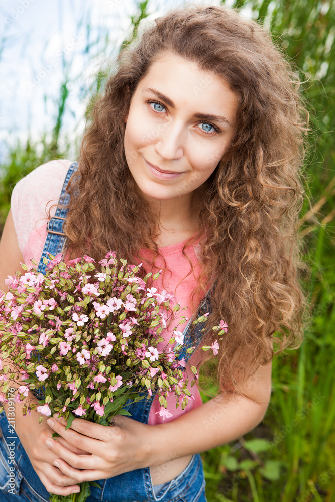 Beautiful woman with bouquet of pink flowers smiling, summer or congratulations concept Beautiful woman with bouquet of pink flowers smiling, summer or congratulations concept