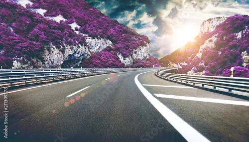 Fotografering Paisaje surreal de curva de la carretera y montañas