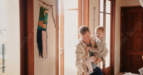 Happy little daughters welcoming father home from work