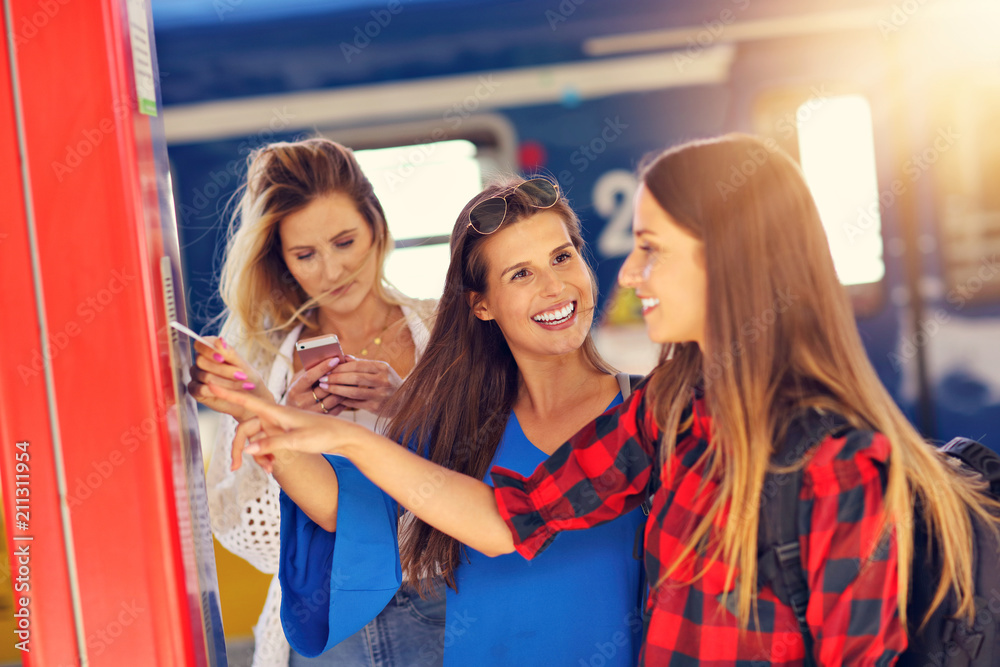 Group of girl friends tourists on railway platform with ticket Group of girl friends tourists on railway platform with ticket