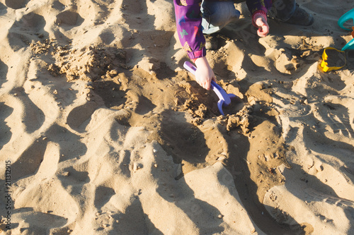 A child playing in the sand on beach. Evening lighting photo