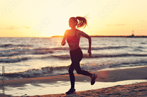 Woman running alone at beautiful dusk on the beach