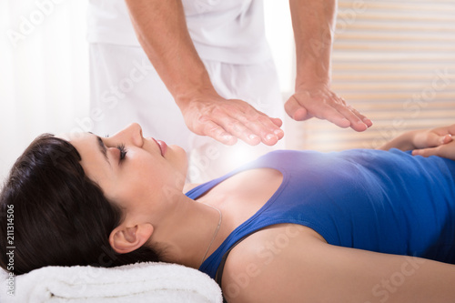 Woman Having Reiki Healing Treatment