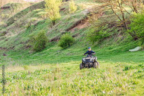 The boy skates on a quad bike in a beautiful area.