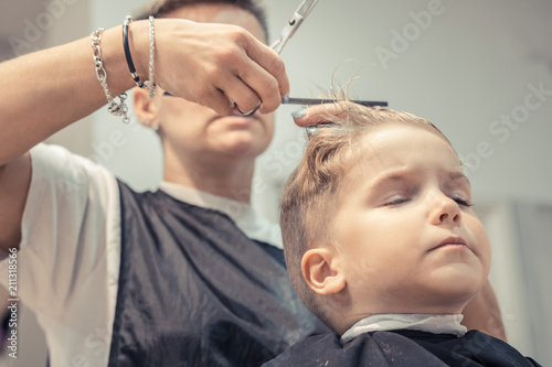 Small boy during haircut at hair salon.