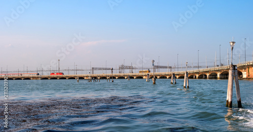 Ponte della Liberta -meaning Freedom Bridge- linking Venice to Mestre in the mainland. On the bridge the train rides. On the bridge bus rides. In the foreground, the fairway pillars