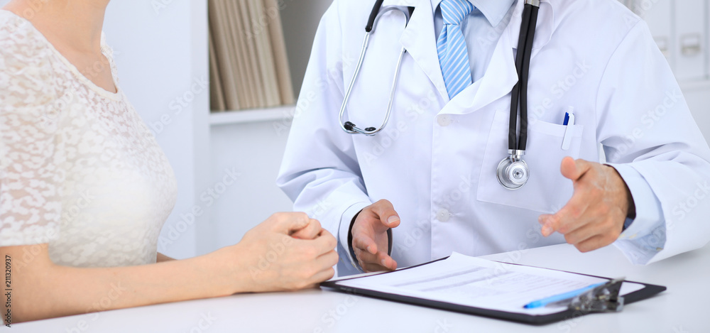 Doctor and patient talking while sitting at the table . Concept of support and trust in medicine Doctor and patient talking while sitting at the table . Concept of support and trust in medicine