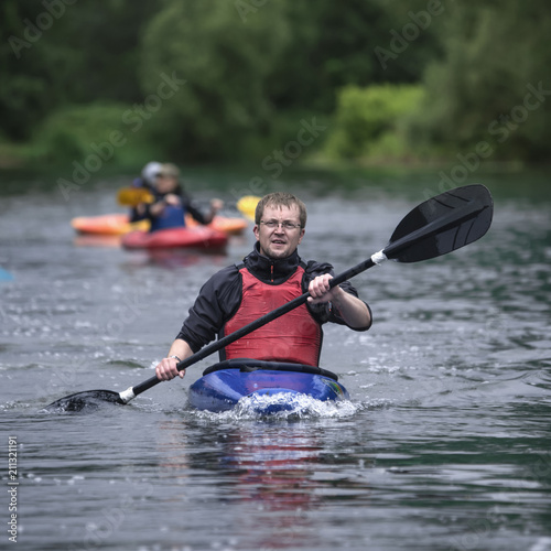 Wallpaper Mural middle-aged man actively manages a sports boat with a kayak on a wide river. Torontodigital.ca