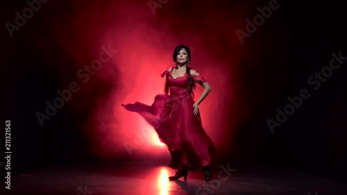 Dancer in an incendiary dance of Argentine flamenco. Light from behind. Smoke background