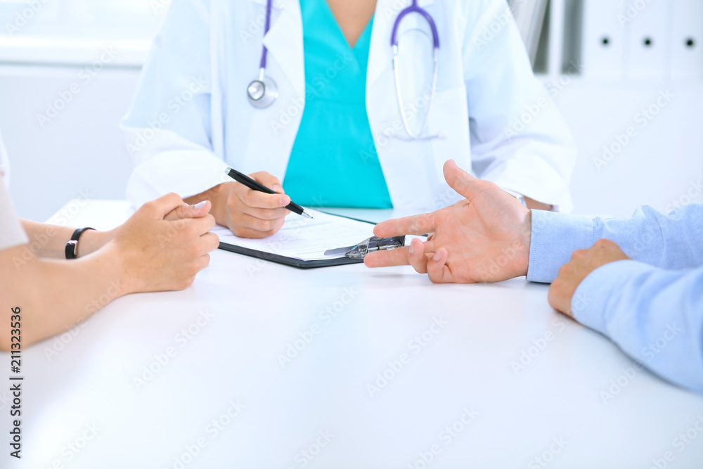 Doctor and family couple of patient are discussing something, just hands at the table. Medicine concept Doctor and family couple of patient are discussing something, just hands at the table. Medicine concept