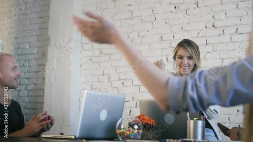 Workers communicate together in the creative office, learn good news, rejoice and celebrate the victory. Coworking