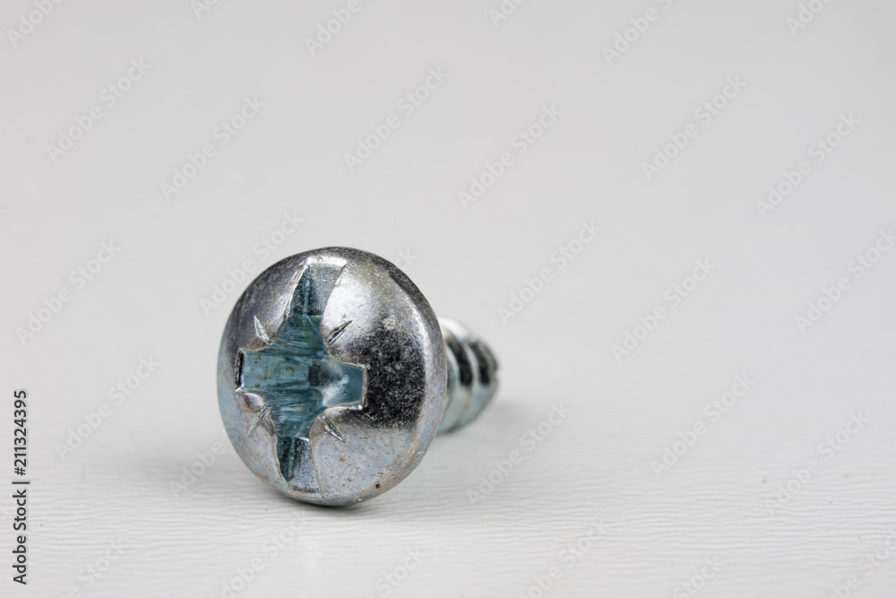 Screw head on a white table. Accessories for screw connections. Screw head on a white table. Accessories for screw connections.