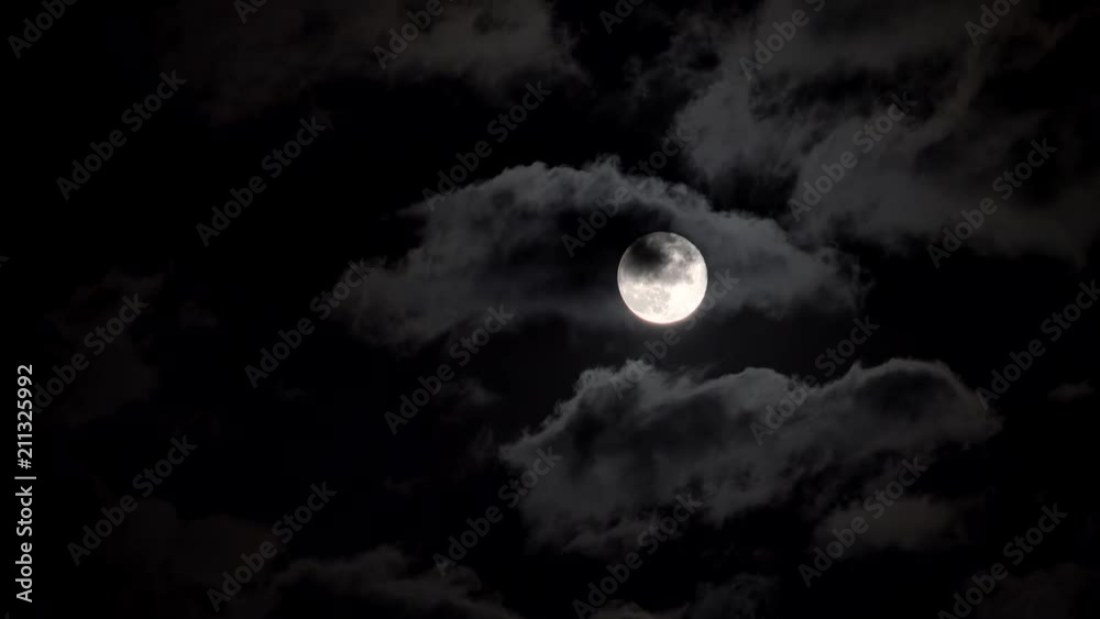 Full moon in a night cloudy sky.