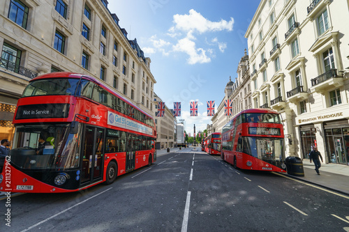 LONDON, ENGLAND - JULY 3, 2016. Regent Street at sunny day with British flags and four red buses © Pawel Pajor