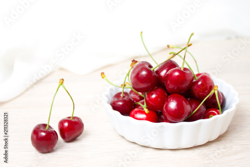 Cherries in white bowl. Cherry on white background. - healthy eating and food concept